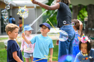 Young summer camp attendees playing with bubbles.